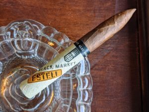 Epic La Rubia Robusto | Timothy Allen Alec Bradley Black Market Esteli Torpedo on a glass ashtray.