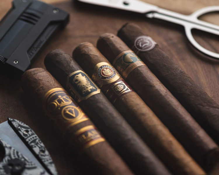Lineup of gorgeous cigars with cutter in background