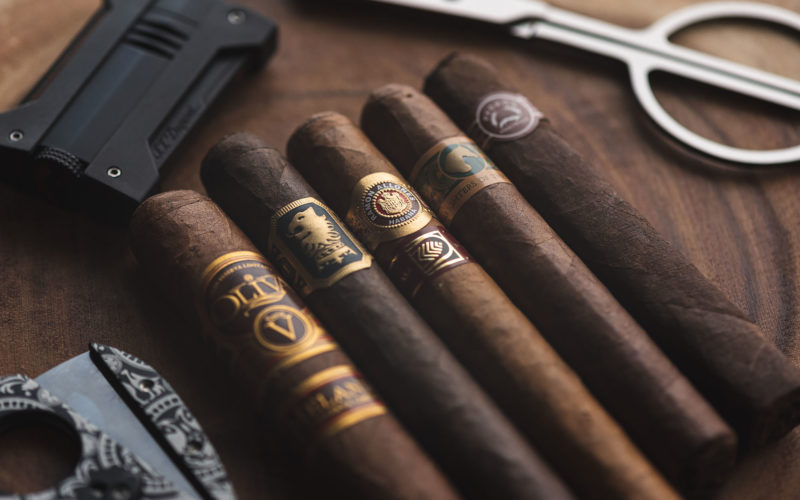 Lineup of gorgeous cigars with cutter in background