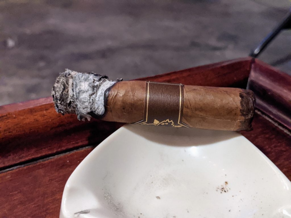 Room101 cigar with some ash hanging on.